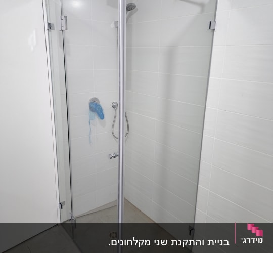 מקלחון זכוכית עם ראש מקלחת ומדף קטן